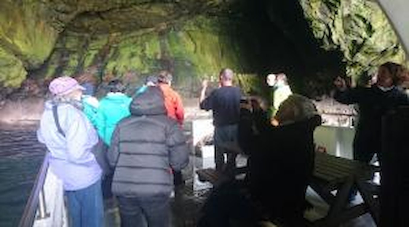 Guests enjoying the experience of the cave where stories are shared and usually spot the shags nesting on the ledges
