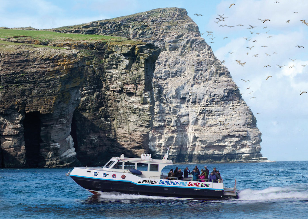 Seabird getting passengers close in to the main seabird colony on Noss.